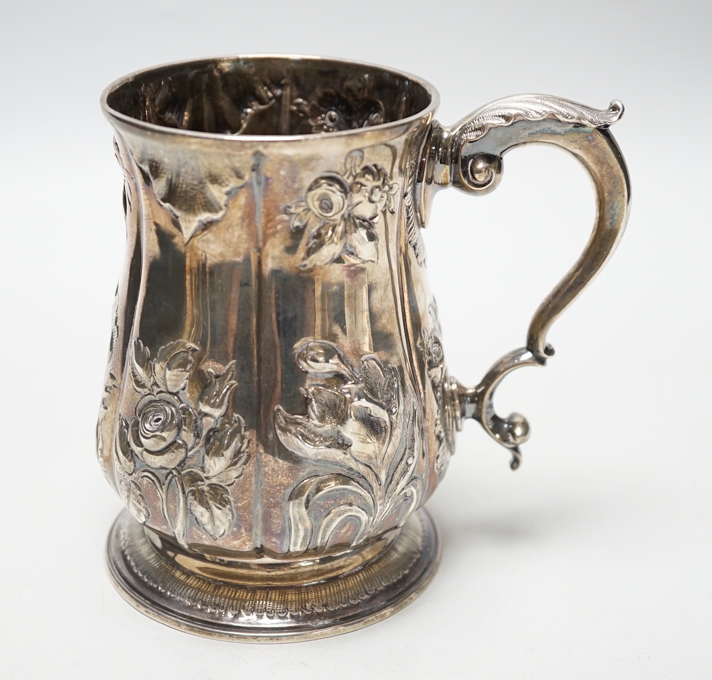 A George III silver baluster mug, with later embossed decoration, Joseph Steward?, London, 1763, 12.9cm, 11.8oz.